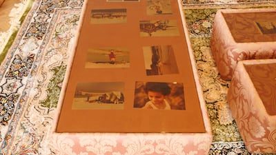 Family photos that inspired the body of work are placed under the glass surface of the coffee table