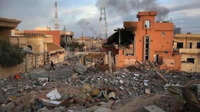 A Kurdish Peshmerga soldier passes through the rubble of a neighborhood in Sinjar.