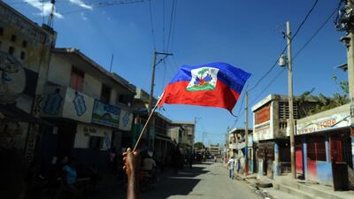 TSA man holds a Haitian flag as he takes part in a protest demanding that Haitian President Michel Martelly steps down in Port-au-Prince. Hector Retamel / AFP Photo