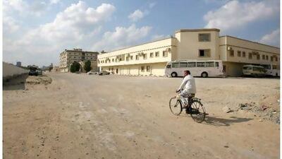 UAE - Ajman - Dec 01 - 2011: A man riding a bicycle on anpaved road in the Jurf area of Ajman ( Jaime Puebla - The National Newspaper )