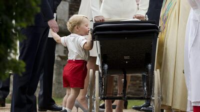 Britain’s Prince George gets up on tiptoes to peek into the pram of Princess Charlotte flanked by his parents Prince William and Kate the Duchess of Cambridge as they leave after Charlotte’s Christening at St Mary Magdalene Church in Sandringham, England. Britain’s royals on July 22, 2015 celebrate the second birthday of George, the first child of Prince William and his wife Kate. Matt Dunham / AP photo