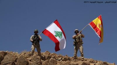 A handout picture released by the Lebanese army on August 19, 2017 shows Lebanese soldiers holding the Spanish flag alongside their own in a show of solidarity with Spain, where attacks claimed by ISIL killed 14 people. Photo via Lebanese army website