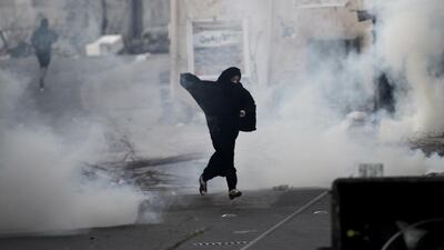A Bahraini anti-government female protestor runs for cover. Mohammed Al Shaikh / AFP Photo