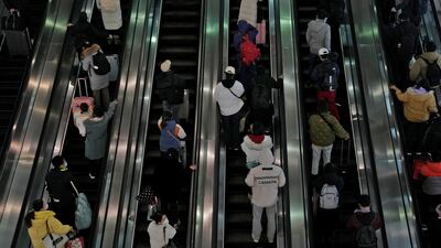 Travellers ride on the escalator at the West Railway Station in Beijing. AP Photo