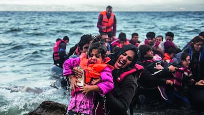 Migrants make land from an overloaded rubber dinghy as they arrive on the coast near Skala Sikaminias, Lesbos island, Greece in October. Filip Singer / EPA