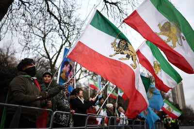Anti-Iranian government protesters wave flags from the regime of Shah Mohammed Reza Pahlavi outside the Iranian embassy in London on January 12. AFP