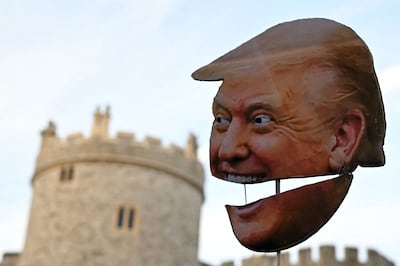 A demonstrator holds a placard of Donald Trump's face outside Windsor Castle. AFP