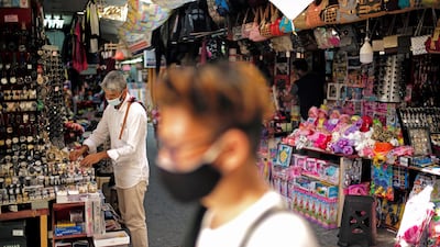A salesman wearing a face mask, displays his goods after opening his shop in a traditional market in Manama, Bahrain. Reuters