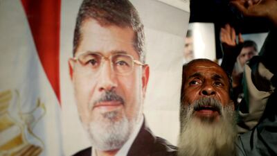 The marchers carried pictures of the deposed president, flashing victory signs and chanting, "Our blood and souls we sacrifice for Morsi." Hassan Ammar / AP Photo