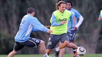 Diego Forlan, centre, dribbles past his Uruguay teammate Diego Perez during pre-World Cup training at Canelones, near Montevideo.