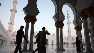Visitors pass through the arched walkways of Sheikh Zayed Grand Mosque a day before Eid Al Adha begins in October 2014. Silvia Razgova / The National