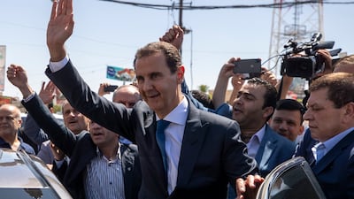 Syrian President Bashar Al Assad waves at a polling station during the presidential elections in Douma, Syria, on May 26, 2021. President Assad issued a decree on Sunday, July 11, 2021, awarding a 50 per cent pay rise to hundreds of thousands of civil servants and military members. AP