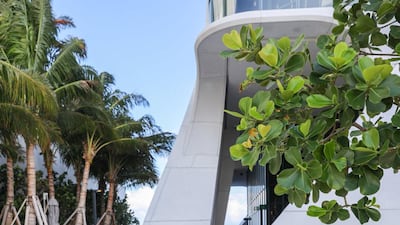 Curved gardens and pools ring the base of the tower.