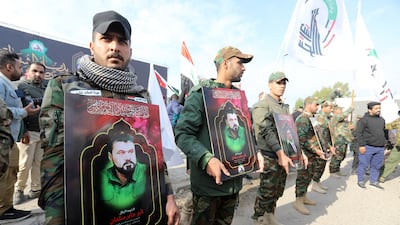Members of the Popular Mobilisation Forces carry images of comrades who were killed in recent retaliatory US air strikes in western Iraq. EPA
