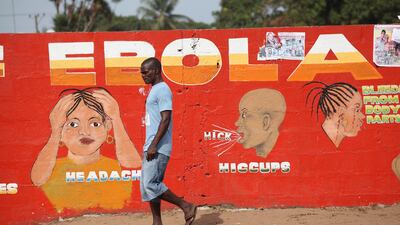A Liberian man walks by an Ebola awareness painting on a wall in downtown Monrovia, Liberia, on March 22, 2015. EPA