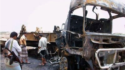 Yemeni men inspect the scene where a suicide bomber driving a pickup truck targeted army personnel carriers at the entrance to a military camp in Aden yesterday. AFP PHOTO / STR