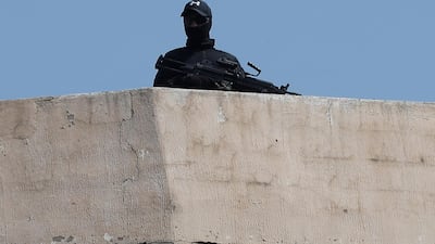 A Lebanese Hezbollah fighter stands guard on a rooftop outside Beirut on Tuesday. AP