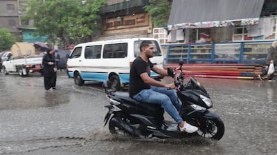 A man rides a motorcycle during rain shower in Cairo, Egypt. EPA