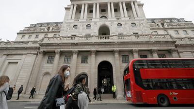 Pedestrians wearing face masks pass the Bank of England in London. The central bank reaffirmed its expectation that the economy will rebound by 7.25 per cent this year. AP