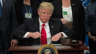 US president Donald Trump takes the cap off a pen to sign an executive order to start the Mexico border wall project at the Department of Homeland Security facility in Washington, DC, on January 25, 2017. Nicholas Kamm / AFP