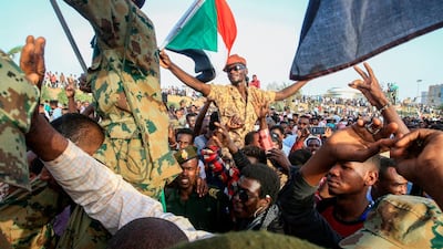Sudanese protesters shout slogans as they carry soldiers during a rally outside the army complex in Sudan's capital Khartoum. AFP