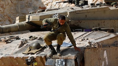 An Israeli soldier jumps off a Merkava tank at an undisclosed location on the border with Lebanon on October 22. AFP
