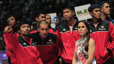 Manny Pacquiao talks to his Ki-Sorento basketball club teammates before their PBA game against Blackwater-Elite on Sunday. His wife, Jinky, is shown at right. Romeo Ranoco / Reuters
