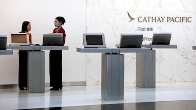Attendants chat at the First Class counter of Cathay Pacific Airways at Hong Kong Airport. The airline said it would again honour its mis-priced tickets. Reuters