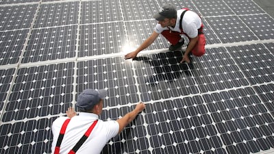 Workers perform maintenance on solar panels on the roof of a warehouse in Buerstadt, Germany. Getty Images