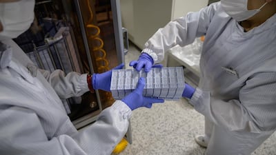 Staff members restock a machine with components used in testing for Covid-19 novel coronavirus. AFP