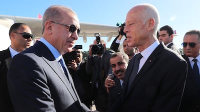 Tunisian President Kais Saied, right, welcomes Turkish President Recep Tayyip Erdogan on his arrival in Tunis. AFP