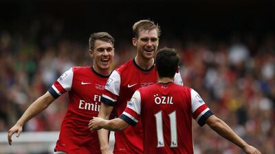 Arsenal midfielder Mesut Ozil, right, celebrates after Arsenal's Per Mertesacker scored against Stoke. Adrian Dennis / AFP
