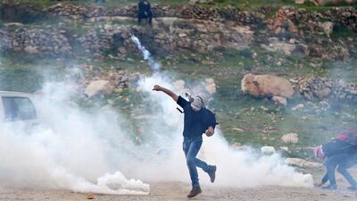 A Palestinian protester hurls back a tear gas canister fired by Israeli troops during clashes near Israel's Ofer Prison near the West Bank city of Ramallah, March 7, 2017. REUTERS/Mohamad Torokman