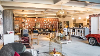 Concept-Me’s creative space in Al Quoz. The warehouse features a bright-red, classic Corvette Stingray, visible on the right, as well as accent walls covered in patterned wallpapers. Courtesy Concept-Me