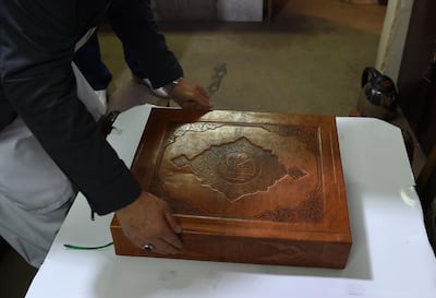 Afghan master miniature artist Mohammad Tamim Sahibzada shows a handmade Quran made with silk fabric at the Turquoise Mountain Foundation in Mourad Khani, in the old city section of Kabul. AFP