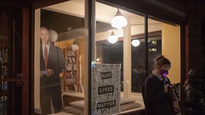 A protester checks election results on her phone in front of a cutout of former President Barack Obama during a Black Lives Matter march in Portland, Oregon. After a record-breaking early voting turnout, Americans head to the polls on the last day to cast their vote for incumbent U.S. President Donald Trump or Democratic nominee Joe Biden in the 2020 presidential election. AFP