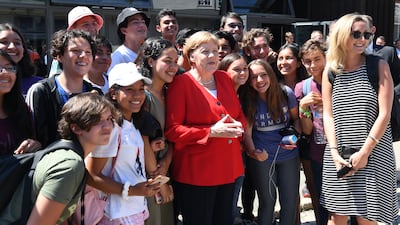 German Chancellor Angela Merkel with some of the schoolchildren who have grown up during her long rule. AFP