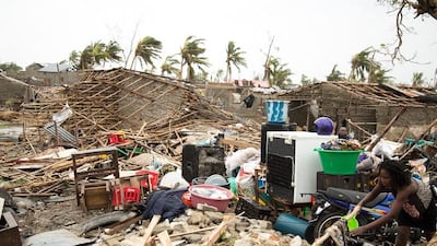 A woman hangs a cloth to dry in a sea of rubble in the Praia Nova area of Beira, Mozambique. IFRC/ EPA