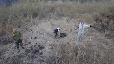 Police bomb disposal specialists in central Israel examine shrapnel on Sunday after the attack. EPA