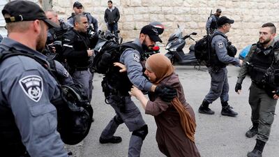 An Israeli policeman pushes back a Palestinian woman outside the Old City of Jerusalem after Israeli forces closed the entrance to the Al Aqsa Mosque compound on March 12. AFP