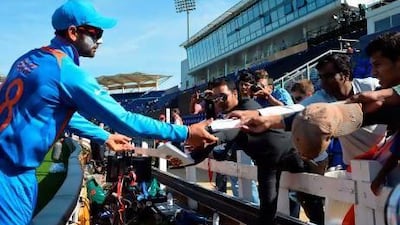 India's Virat Kohli signs autographs for spectators during the warm-up cricket match ahead of the 2013 Champions Trophy opener between India and Australia at The Cardiff Wales Stadium.
