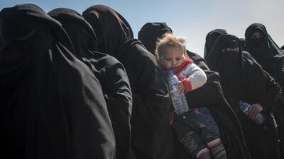 Civilians who have fled fighting in Baghouz wait to board trucks after being screened by members of the Syrian Democratic Forces (SDF) at a makeshift screening point in the desert. Getty Images