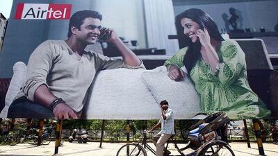 A rickshaw driver talks on his mobile phone as he rides past a billboard outside a railway station in the northern Indian city of Chandigarh: Retailers, telecoms companies and other businesses are heading out of the cities in pursuit of growth among the 742 million Indians who live there.