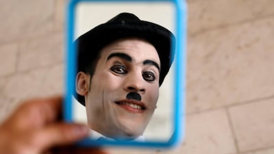 Karim Asir checks his make-up in a mirror before a performance as Charlie Chaplin in Kabul. Reuters