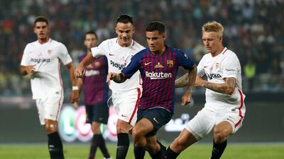 Barcelona's Philippe Coutinho in action with Sevilla's Simon Kjaer and Roque Mesa. Reuters