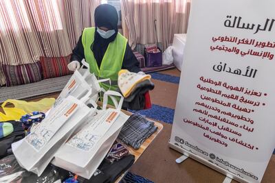 A volunteer packs clothes to be donated to low-income families. Antonie Robertson / The National