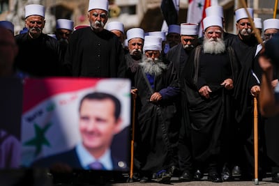 Druze men carry Syrian flags and a picture of President Bashar Al Assad during a rally marking Syria's Independence Day, in the Druze village of Majdal Shams last week. AP Photo