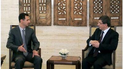 The Syrian president, Bashar al Assad, left, meets the Turkish foreign minister, Ahmet Davutoglu, right, in Damascus on the eve of the Baath party's 64th anniversary.