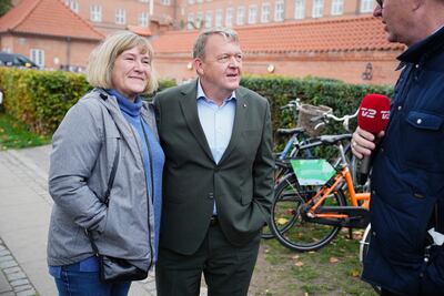 Former prime minister Lars Lokke Rasmussen, centre, with his wife at a polling station in Copenhagen. EPA