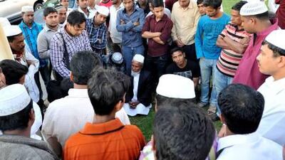 Fellow Bangladeshis stand with Mohammed Idrees who lost two sons in the Al Ain road accident. Charles Crowell / The National
